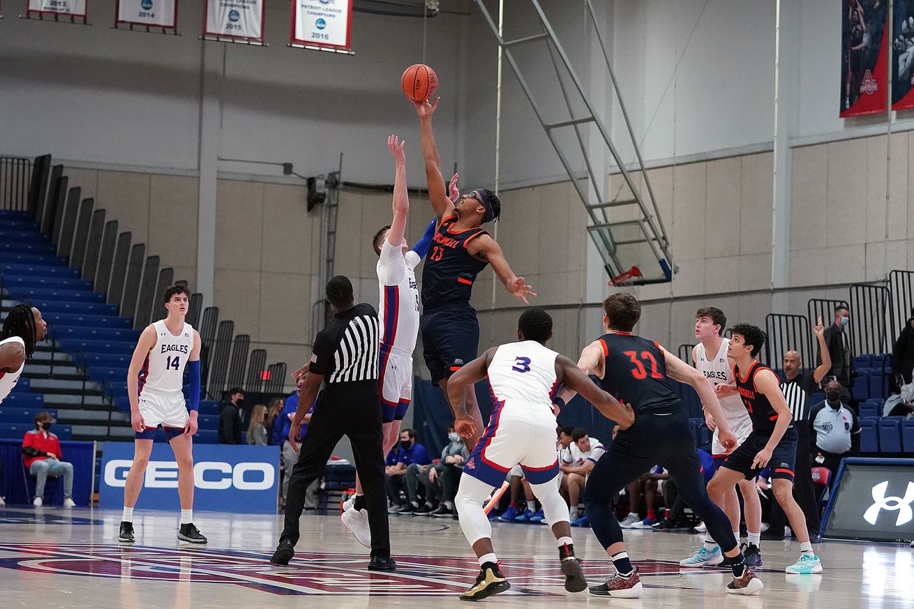 Andre Screen #23 of the Bucknell Bison tips off the ball over Matt Rogers #15 of the American University Eagles during a college basketball game against the American University Eagles at Bender Arena on January 16, 2022 in Washington, DC.