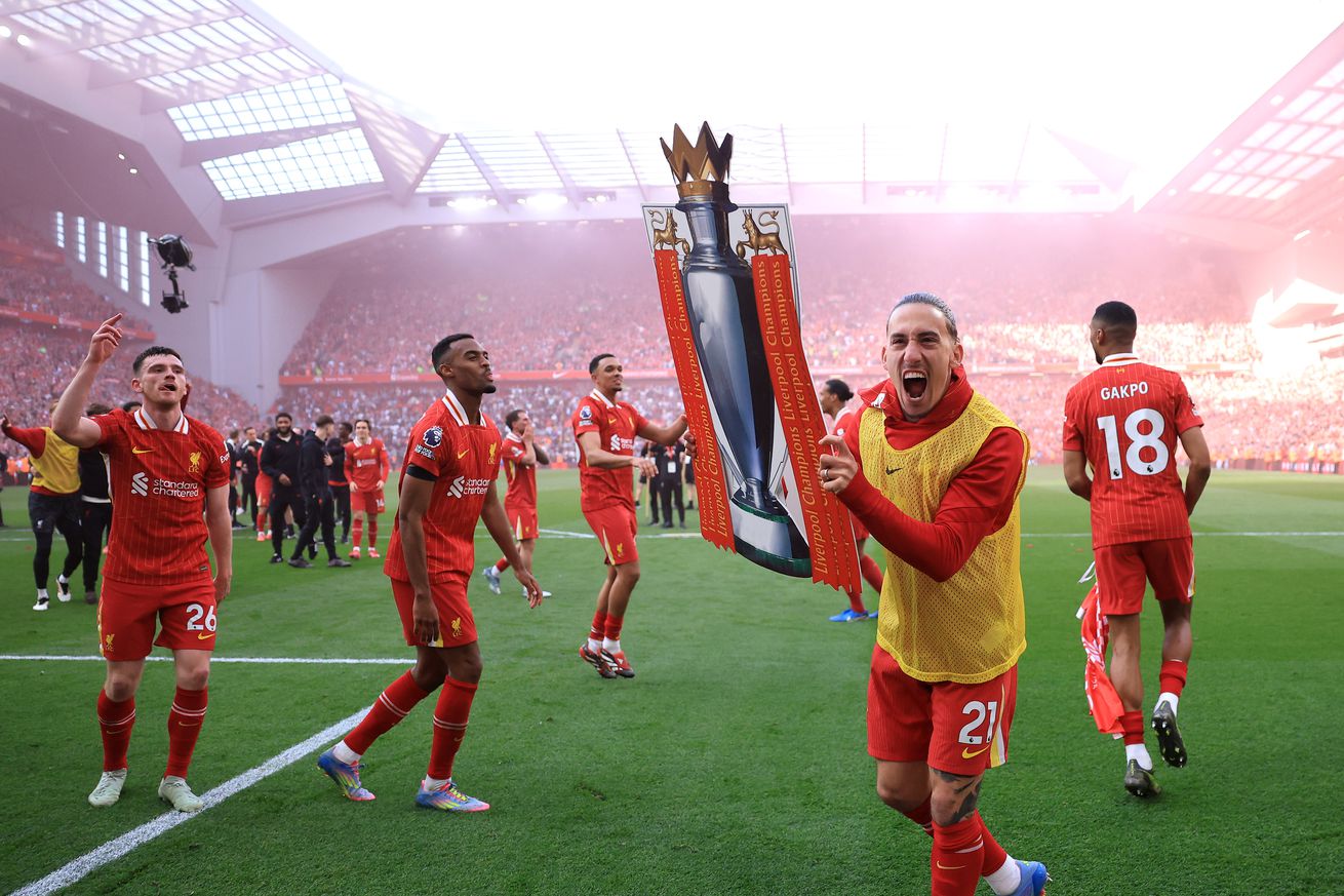 Kostas Tsimikas of Liverpool celebrate with a card board cut out of the Premier League trophy after the teams victory and confirmation of winning the Premier League title in the Premier League match between Liverpool FC and Tottenham Hotspur FC at Anfield on April 27, 2025 in Liverpool, England.